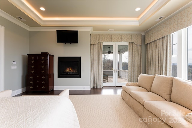 bedroom featuring multiple windows, access to outside, and a tray ceiling