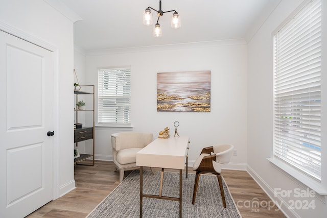 office featuring a notable chandelier, light wood-type flooring, and crown molding