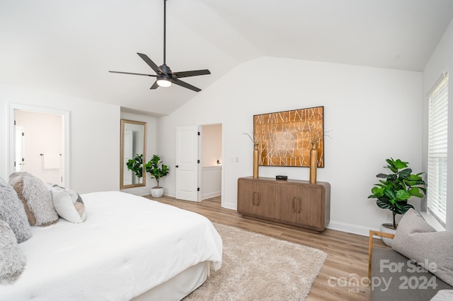 bedroom featuring ceiling fan, light hardwood / wood-style flooring, ensuite bathroom, and vaulted ceiling