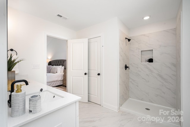 bathroom featuring tile floors, vanity, and tiled shower