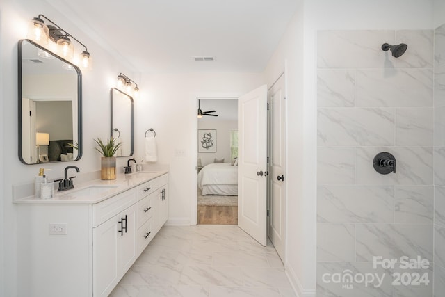 bathroom featuring double sink vanity, tile floors, ceiling fan, and tiled shower