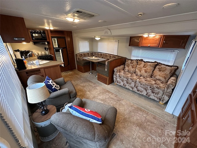 living room with light tile flooring and sink