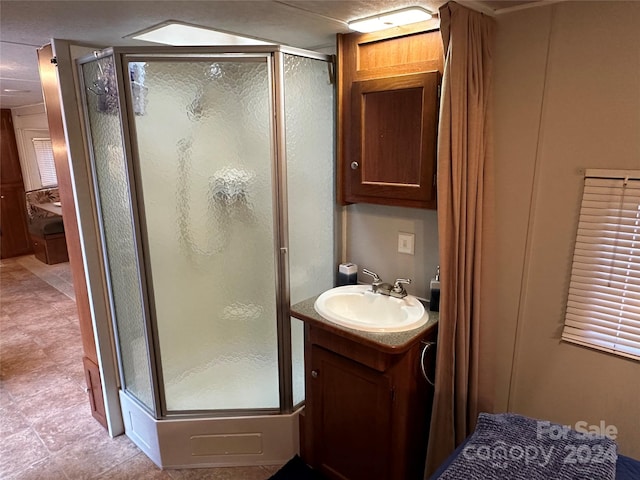 bathroom featuring walk in shower, large vanity, and tile floors