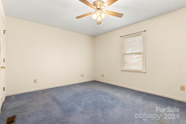 carpeted empty room featuring a textured ceiling and ceiling fan