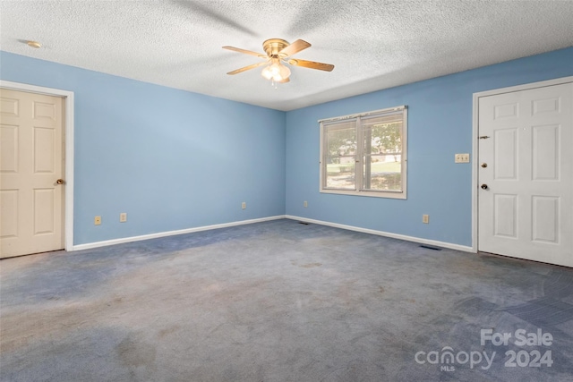 entryway with ceiling fan, a textured ceiling, and dark carpet