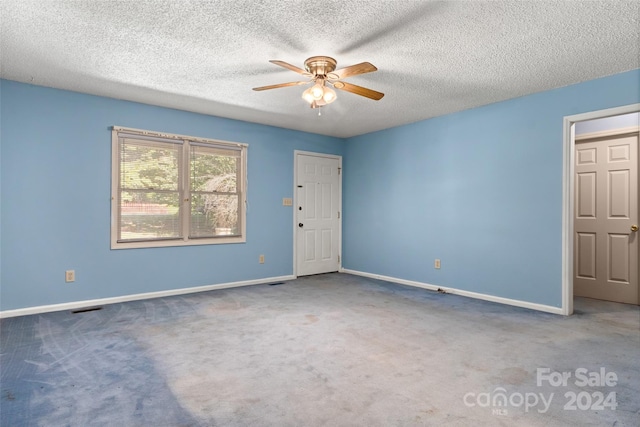 unfurnished room with ceiling fan, a textured ceiling, and carpet flooring