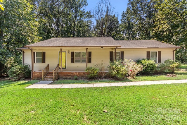 ranch-style home with a porch, a shingled roof, and a front yard