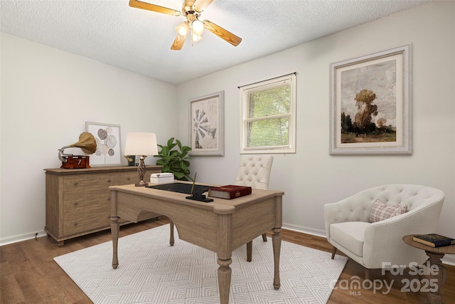 office space with wood finished floors, a ceiling fan, and baseboards