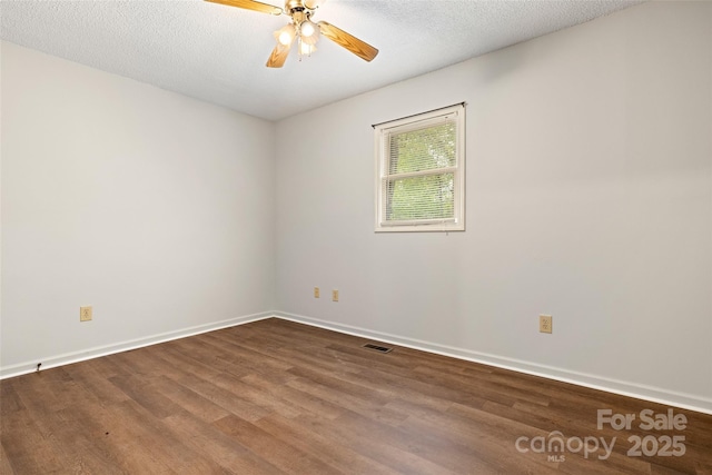 empty room featuring visible vents, baseboards, a ceiling fan, and wood finished floors