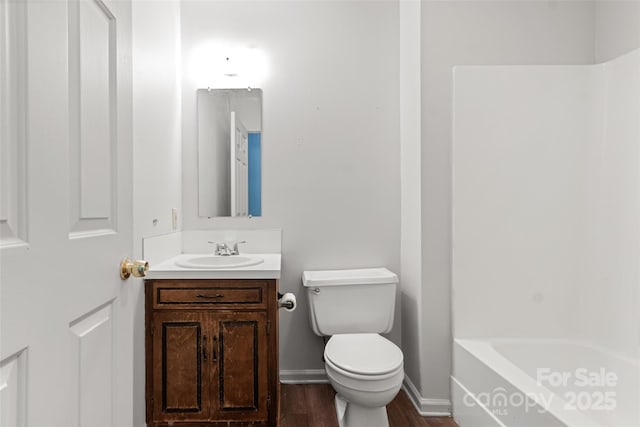 full bathroom featuring baseboards, wood finished floors, vanity, and toilet