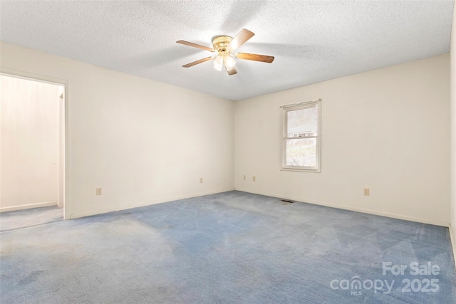 empty room with a textured ceiling, carpet flooring, and a ceiling fan