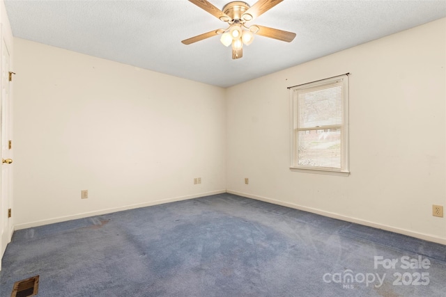 unfurnished room with a textured ceiling, baseboards, visible vents, a ceiling fan, and dark carpet