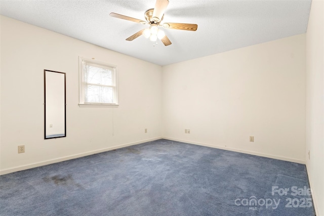 empty room featuring baseboards, a ceiling fan, dark colored carpet, and a textured ceiling