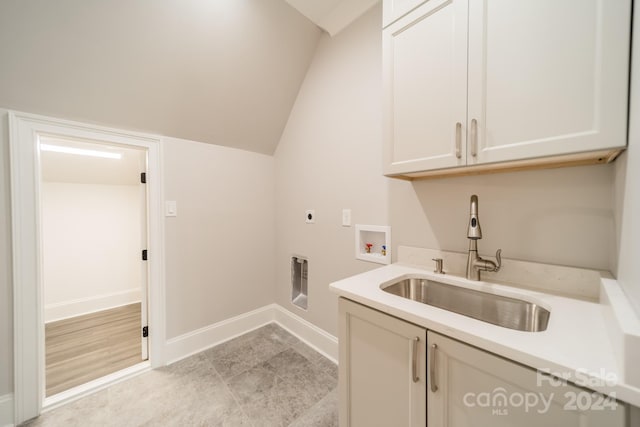 washroom with cabinets, sink, hookup for a washing machine, and hookup for an electric dryer