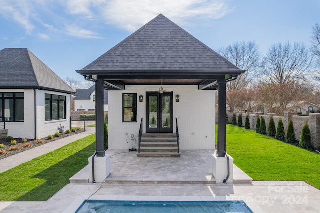 exterior space with ceiling fan, a fenced in pool, and a yard