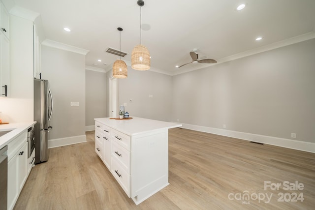 kitchen with white cabinets, appliances with stainless steel finishes, pendant lighting, and a center island