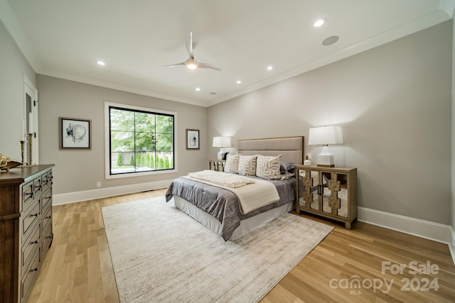 bedroom featuring ceiling fan, crown molding, and light hardwood / wood-style floors