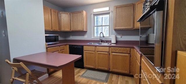 kitchen with sink, dishwasher, and light wood-type flooring