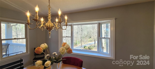 dining room with an inviting chandelier and a textured ceiling