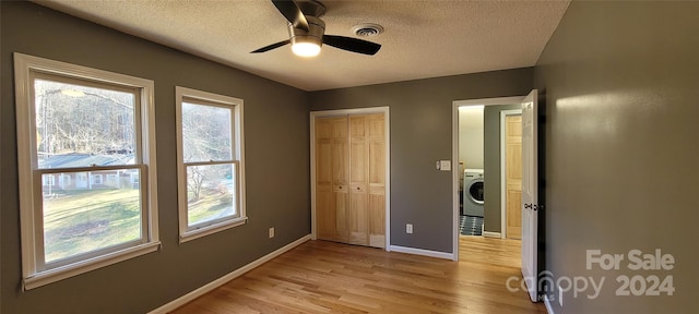 empty room featuring washer / clothes dryer, ceiling fan, a textured ceiling, and light wood-type flooring