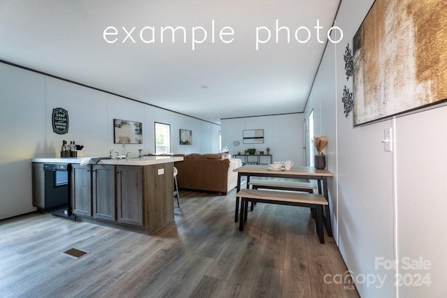 kitchen with hardwood / wood-style floors, black dishwasher, and sink