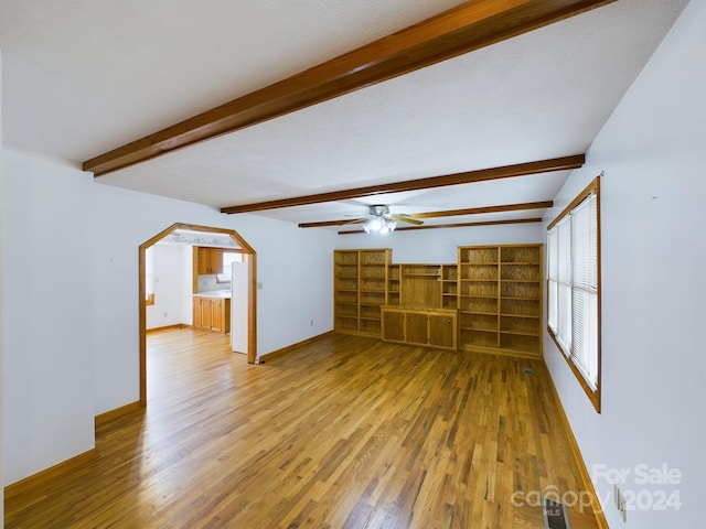 unfurnished living room with ceiling fan, light hardwood / wood-style flooring, and beamed ceiling