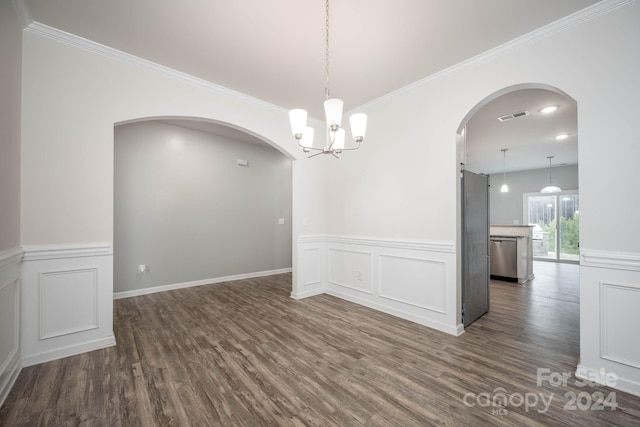 spare room with ornamental molding, dark hardwood / wood-style floors, and an inviting chandelier