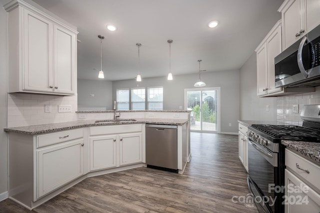 kitchen featuring backsplash, stainless steel appliances, wood-type flooring, and decorative light fixtures