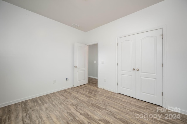 unfurnished bedroom featuring a closet and light wood-type flooring