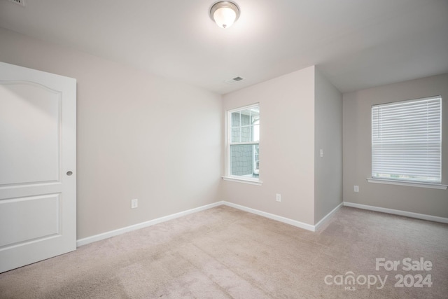 unfurnished room featuring light colored carpet