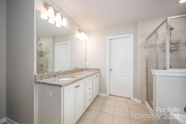 bathroom featuring dual sinks, tile floors, walk in shower, and vanity with extensive cabinet space