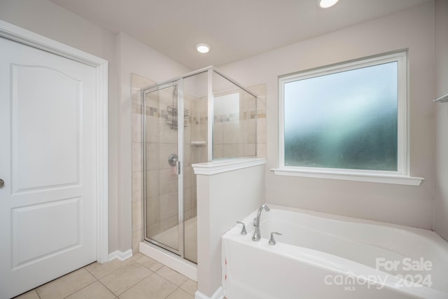 bathroom featuring independent shower and bath and tile flooring