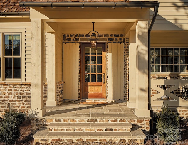 view of exterior entry featuring covered porch