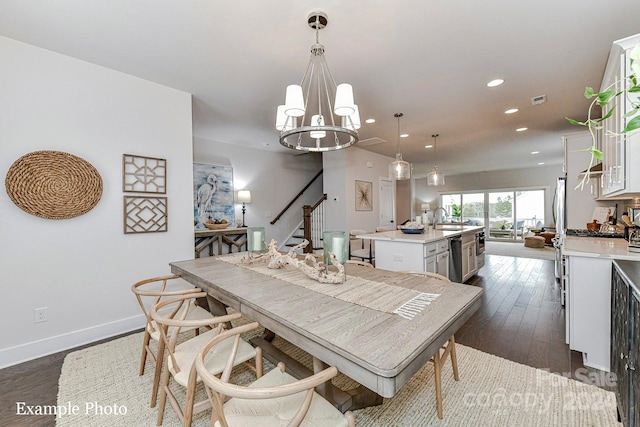 dining room featuring dark hardwood / wood-style floors, sink, and a chandelier