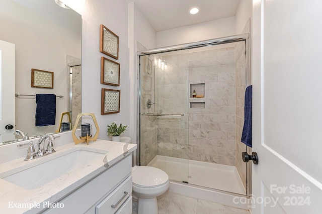 bathroom with toilet, a shower with door, vanity with extensive cabinet space, and tile flooring