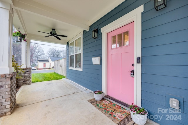 view of exterior entry featuring a porch and ceiling fan