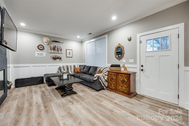 living room with ornamental molding and light wood-type flooring