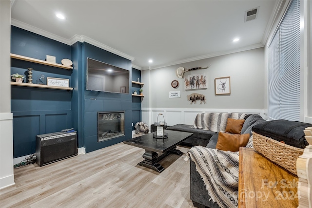 living room with ornamental molding, a fireplace, and light hardwood / wood-style flooring