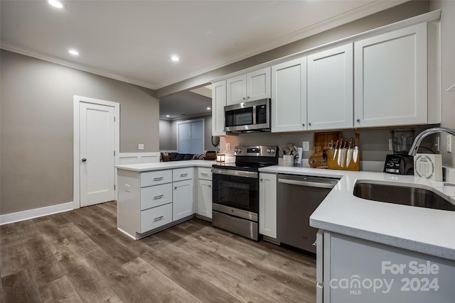 kitchen featuring appliances with stainless steel finishes, white cabinetry, dark wood-type flooring, and sink