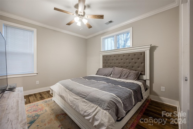 bedroom with crown molding, dark hardwood / wood-style flooring, and ceiling fan