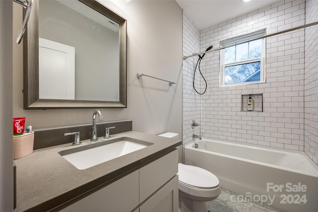 full bathroom with large vanity, toilet, and tiled shower / bath