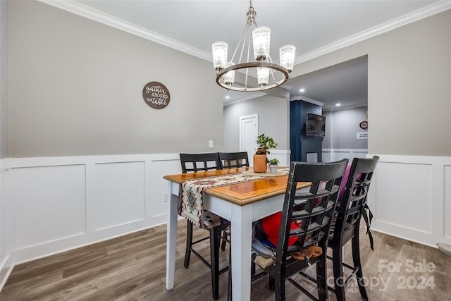 dining area with crown molding, a notable chandelier, and wood-type flooring