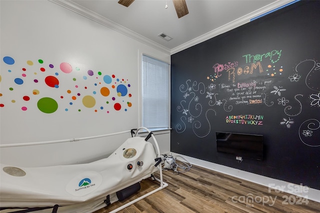 interior space featuring ceiling fan, crown molding, and hardwood / wood-style flooring