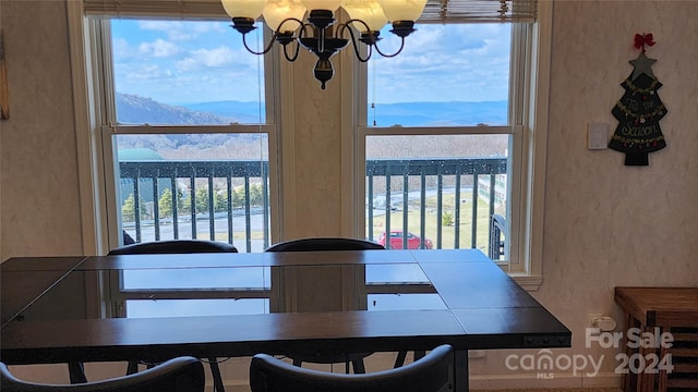 dining area featuring a notable chandelier and a water and mountain view