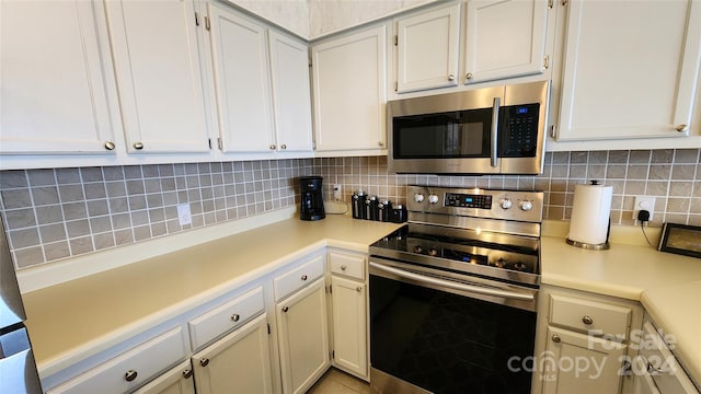 kitchen featuring tasteful backsplash, white cabinetry, and appliances with stainless steel finishes