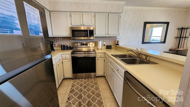 kitchen featuring light tile flooring, tasteful backsplash, stainless steel appliances, sink, and ornamental molding