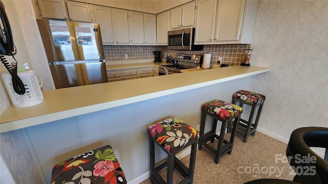 301 Pinnacle Inn Rd Unit 2306, Beech Mountain, NC 28604 - kitchen featuring tasteful backsplash, appliances with stainless steel finishes, a textured wall, baseboards, and a peninsula