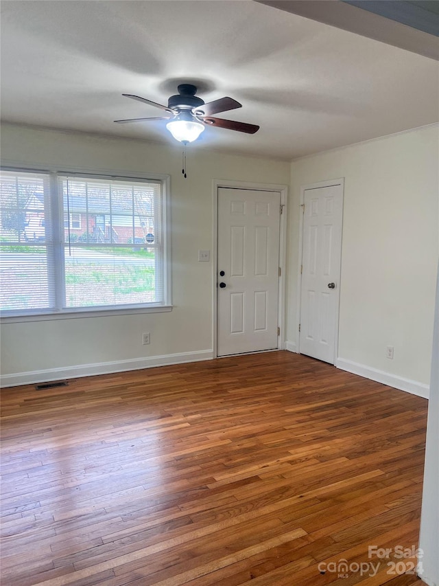 unfurnished room with ceiling fan and dark wood-type flooring