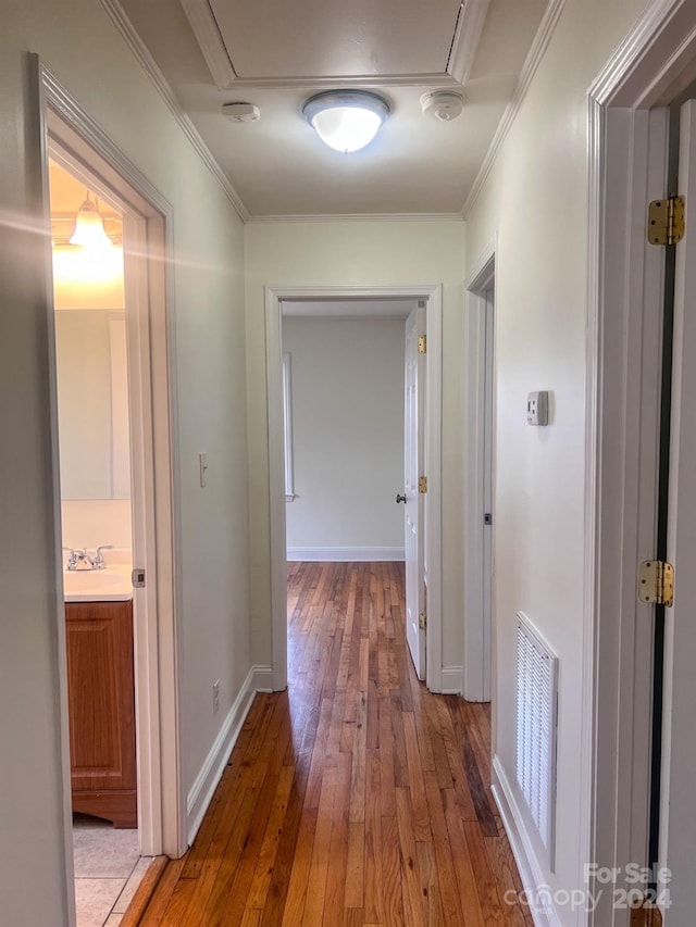 hallway featuring crown molding, sink, and dark wood-type flooring