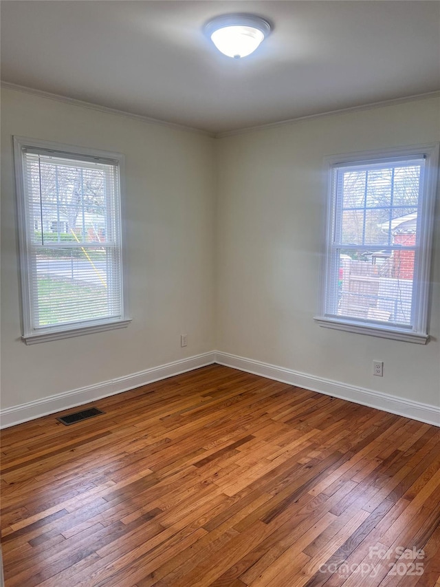 unfurnished room featuring wood-type flooring and ornamental molding